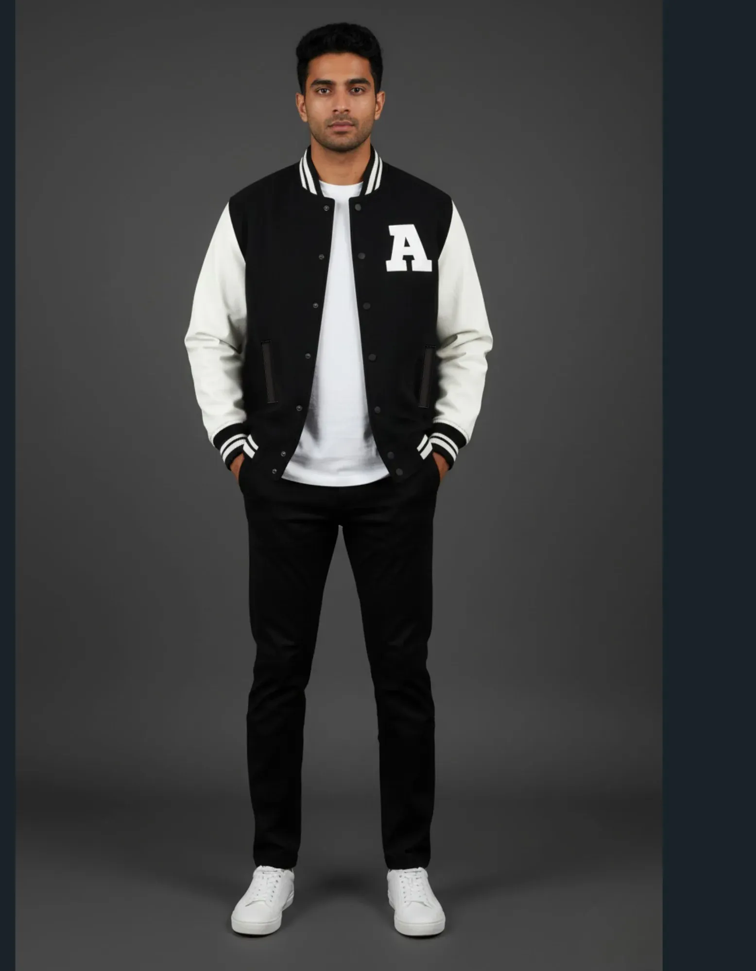 Man wearing a black and white varsity jacket with a letter 'A' on a gray background